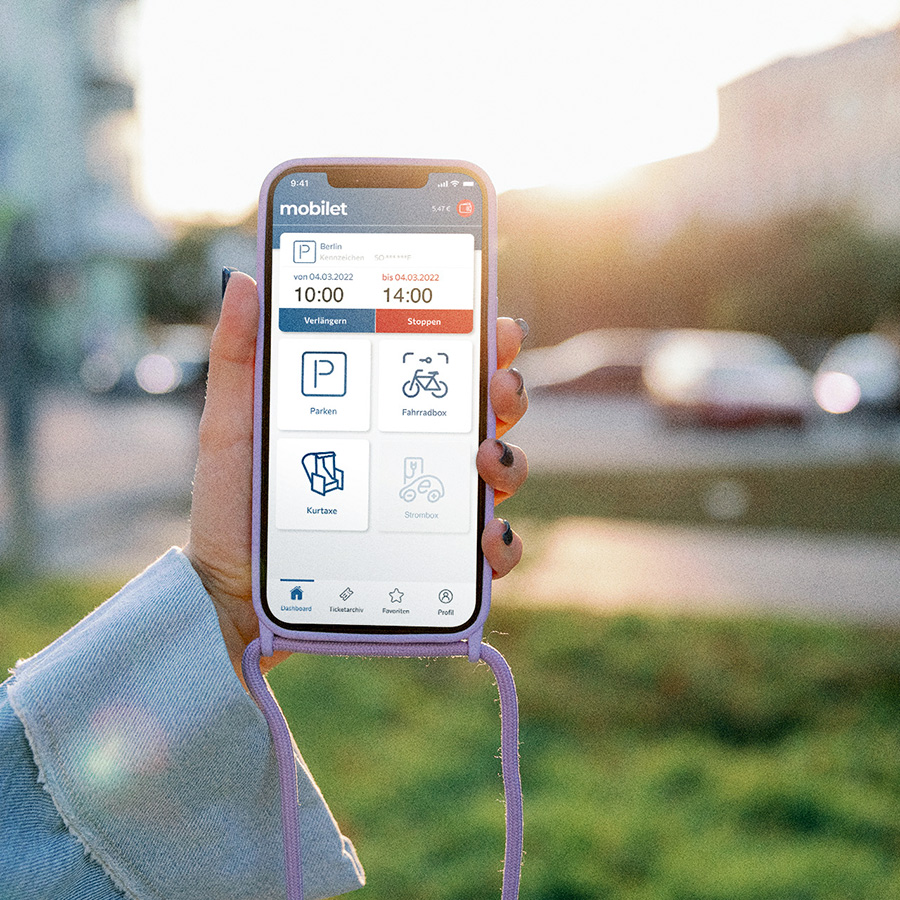 Frau hält ihr Handy mit der geöffneten mobilet App für das digitale Bezahlsystem.